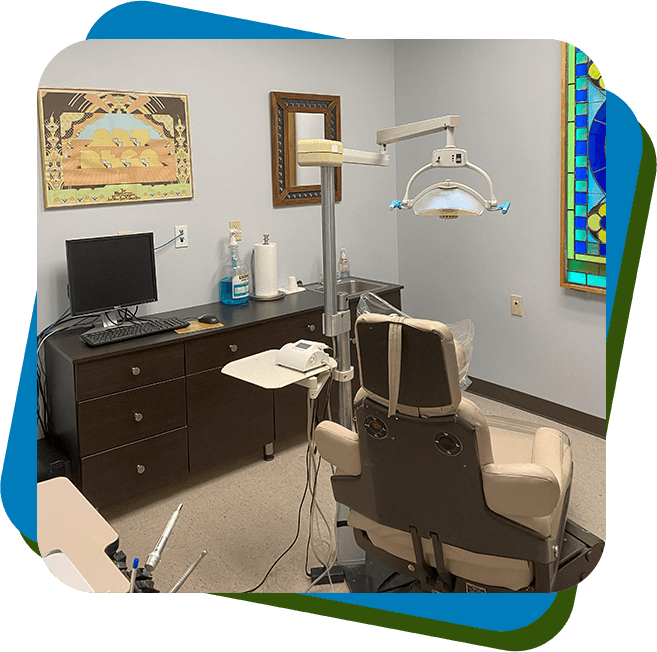 A dentist 's office with a chair and desk.